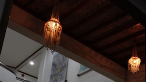 Ein Empfangsbereich mit einem Holzbüro, Blumentöpfen und einer Chandelüster.