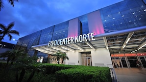 Het exterieur van Expo Center Norte met een moderne glazen gevel en bewegwijzering.