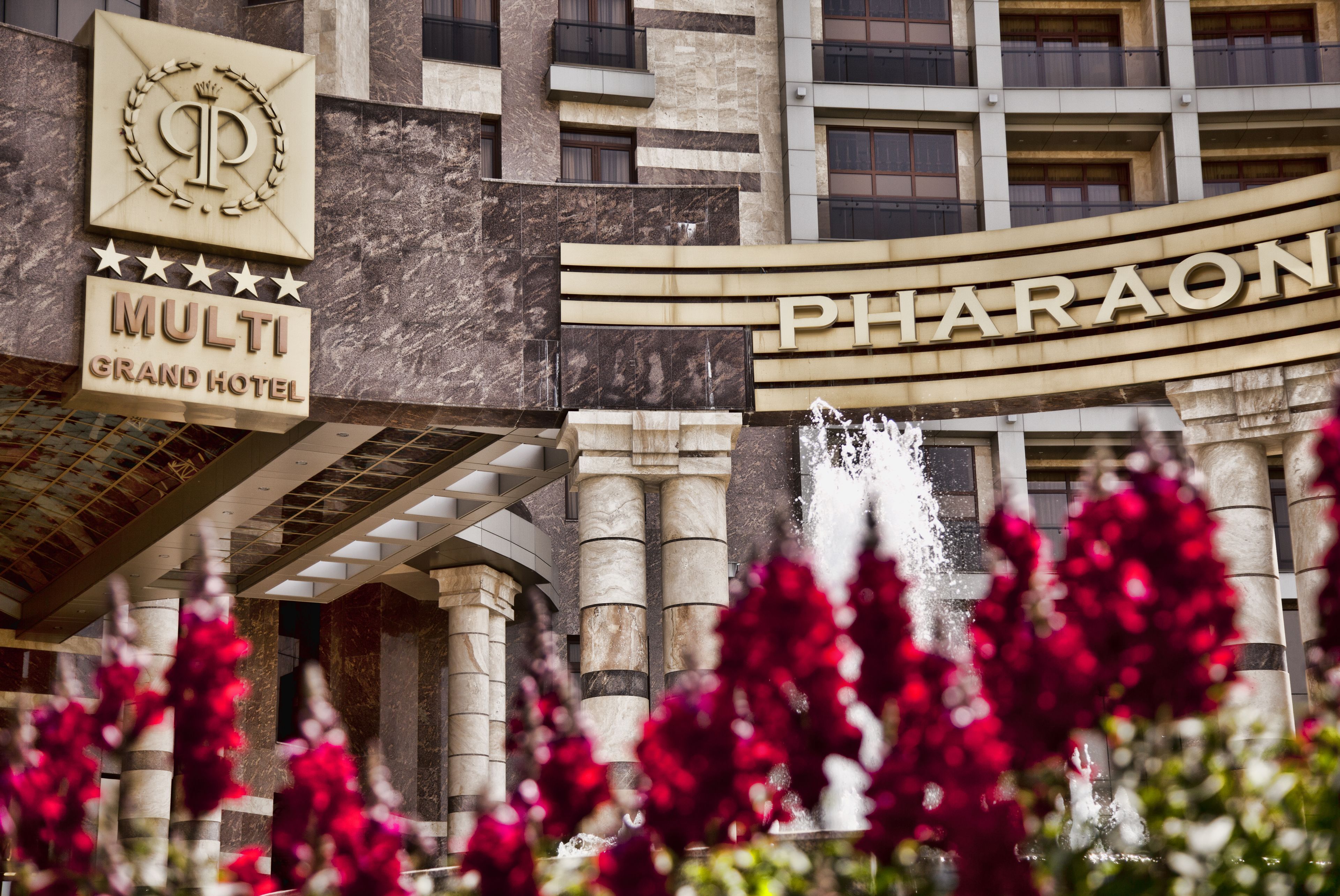 The exterior of the Multi Grand Hotel with a prominent sign for the Pharaon hotel.