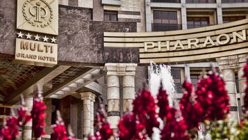 The exterior of the Multi Grand Hotel with a prominent sign for the Pharaon hotel.