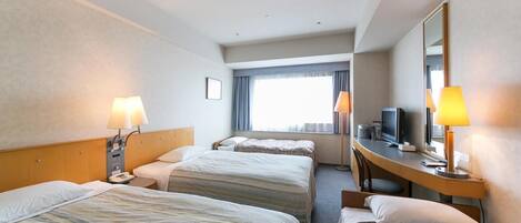 A hotel room with two beds, a desk with a computer, a TV, and a large mirror.