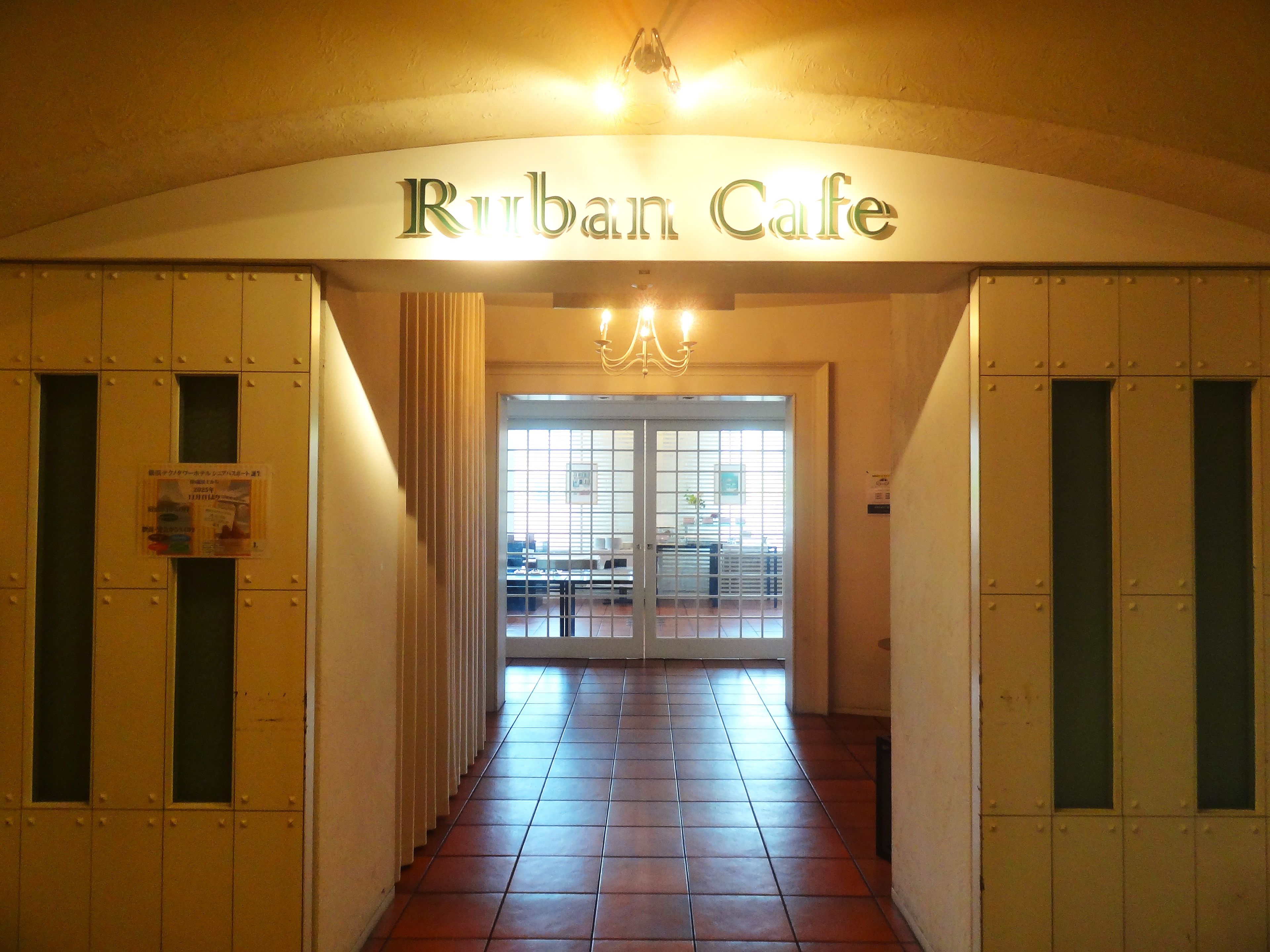 L’entrée du Rurban Cafe, avec son sol carrelé et une enseigne au-dessus de la porte.