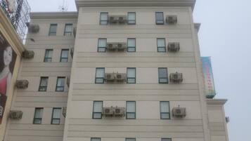 A multi-story building with the signage 'JINJIANG INN' indicating it is a hotel.