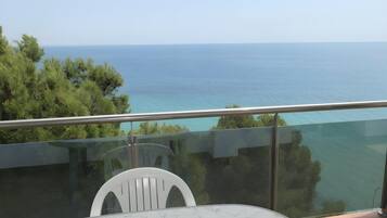 Un balcón con vista despejada al mar y a los árboles.