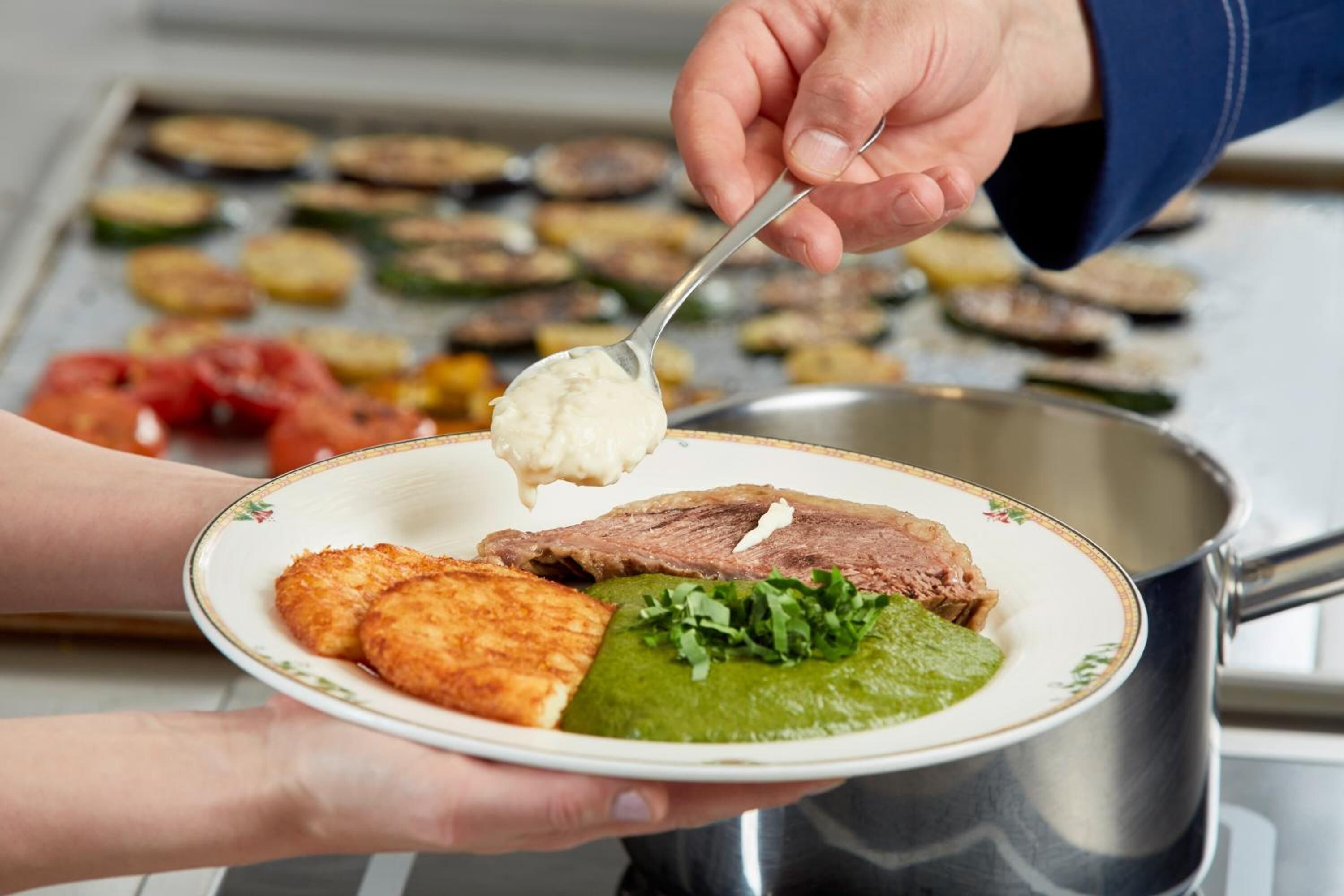 Una persona sirve comida desde una olla a un plato.