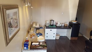 A small kitchenette with a coffee maker, toaster, and various food items on the counter. - Siesta Motel (Olds)