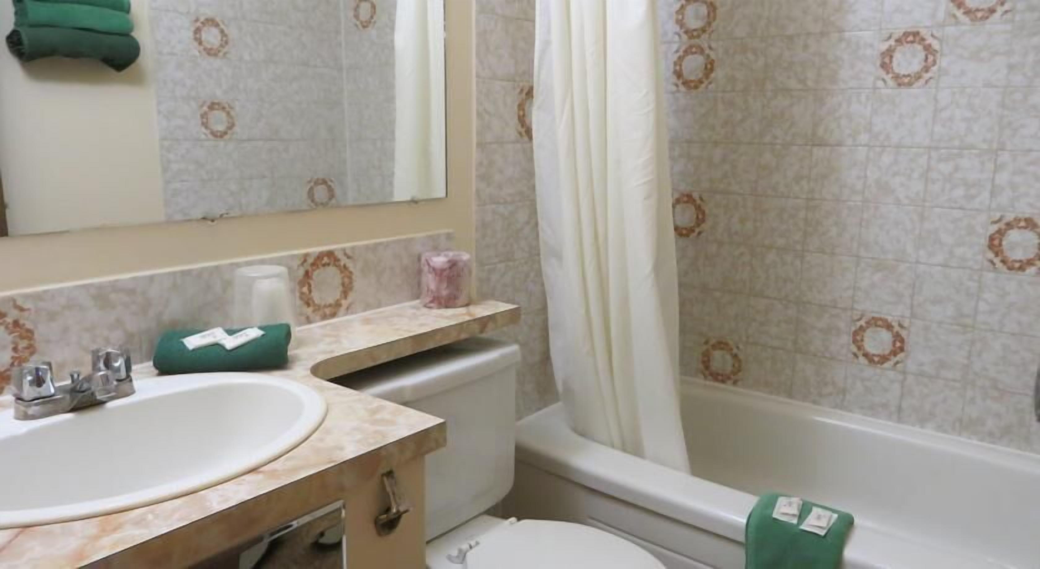 A bathroom with a sink, toilet, and bathtub.