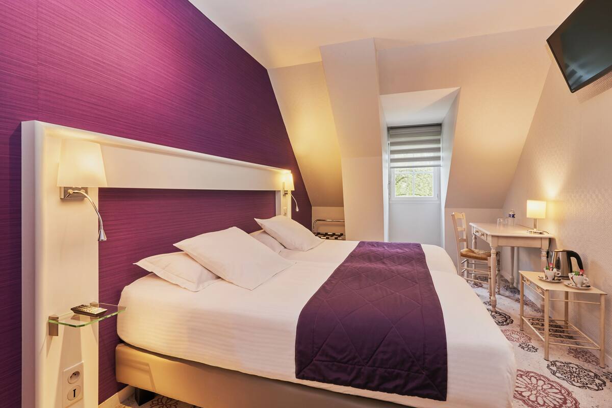 Une chambre d’hôtel moderne avec un grand lit, un bureau et une chaise.