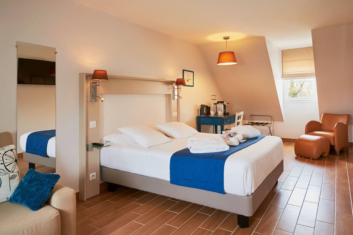 Une chambre d’hôtel moderne avec un grand lit, un bureau, une chaise et une fenêtre donnant sur un beau paysage.