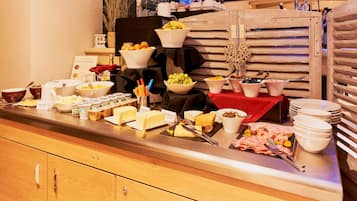 Disposição de buffet com diversos alimentos e utensílios.