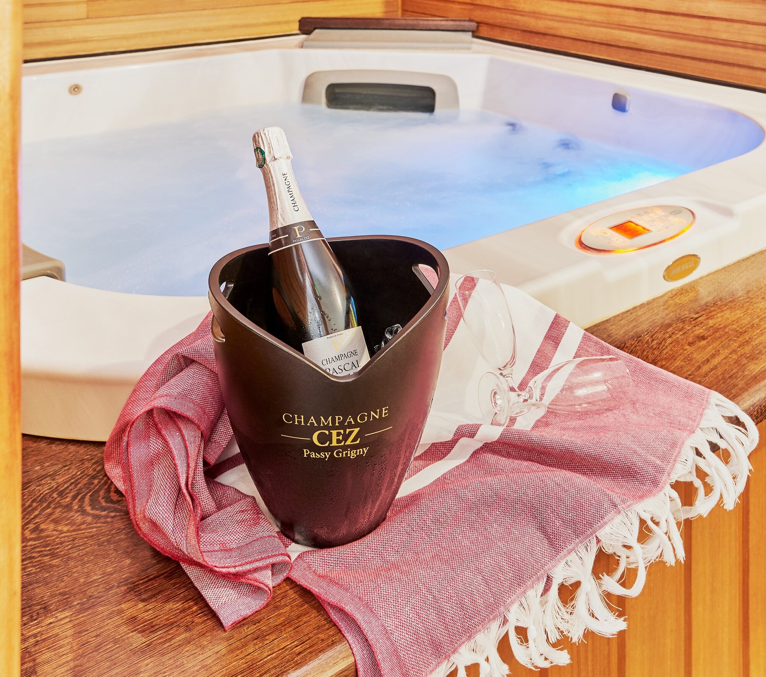 A hot tub with a bottle of champagne in a bucket.