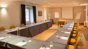 A conference room with a long table, chairs, a projector screen, and a whiteboard. - Domaine de la Tortinière (Veigne)