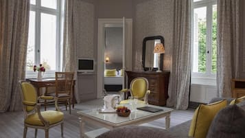 Una habitación bien iluminada con una mesa de comedor para dos personas, un sofá y un televisor.
