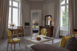 Una habitación bien iluminada con una mesa de comedor para dos personas, un sofá y un televisor.