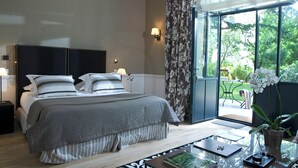 Un dormitorio con cama, lámparas de noche, una mesita de cristal con bandeja y vistas al exterior.