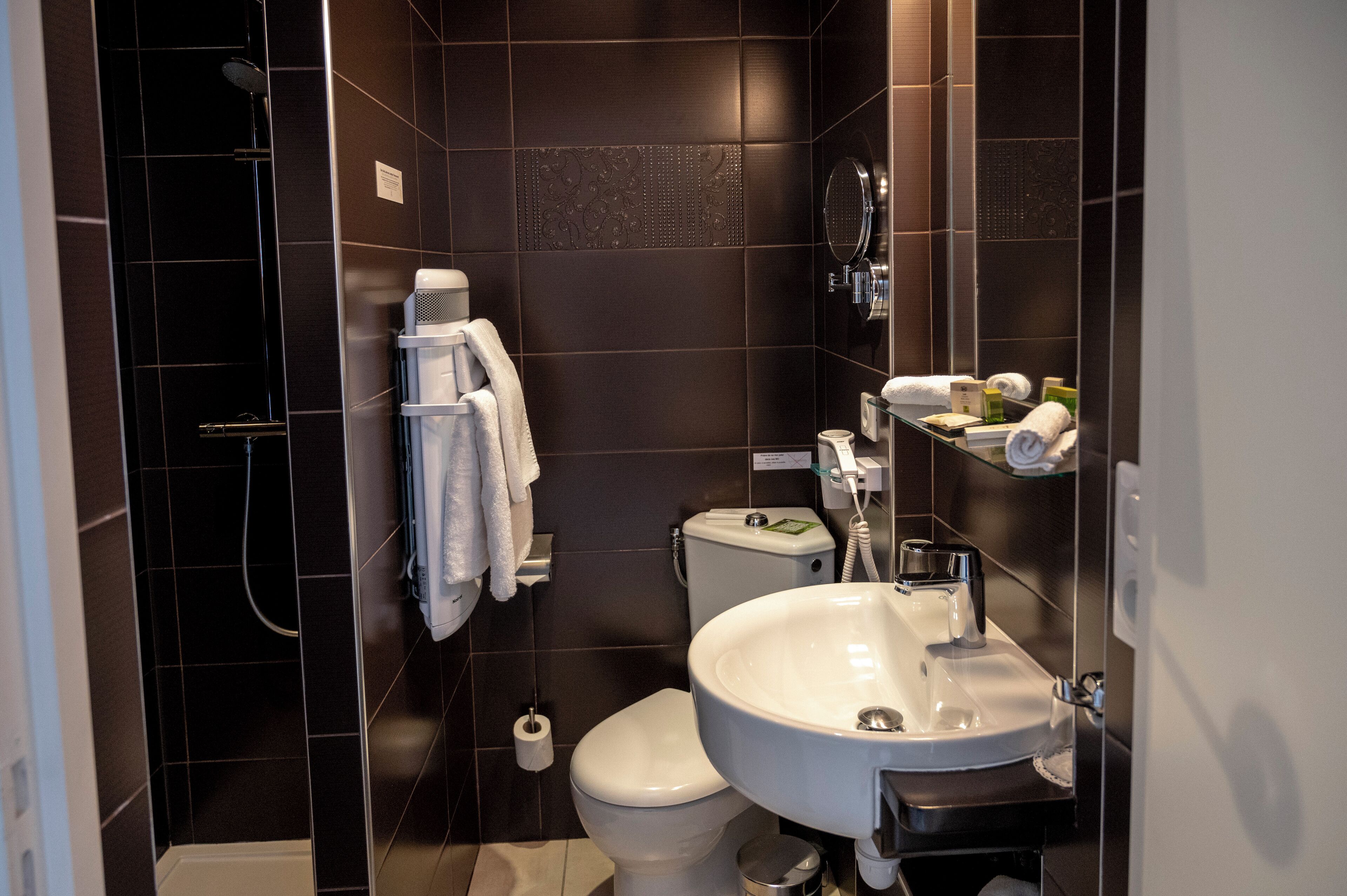 A modern bathroom with a shower, toilet, and sink.