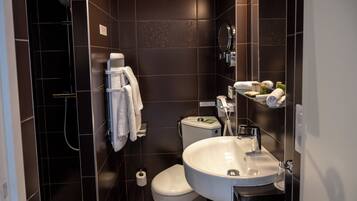 A modern bathroom with a shower, toilet, and sink.