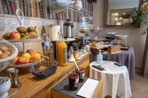 Un bufé de desayuno con diferentes opciones de comida, una máquina de café y un espejo en la pared.