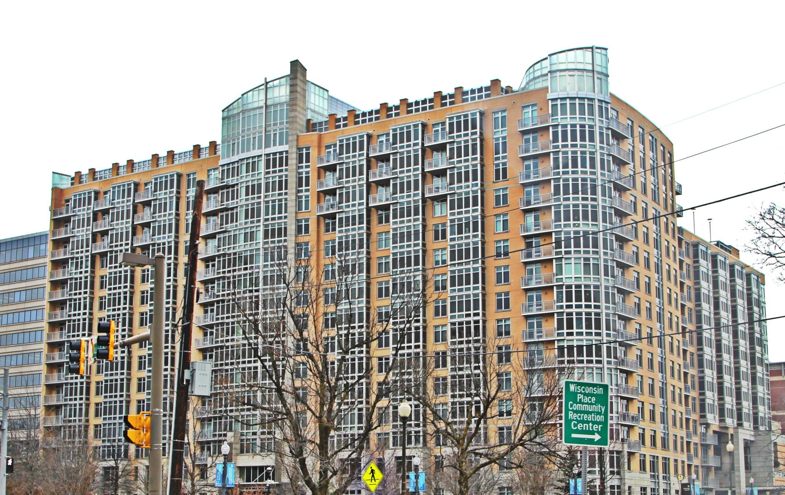 A high-rise building with multiple balconies and a sign indicating the Wisconsin Place Community Recreation Center.