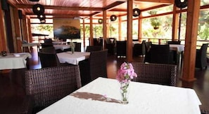 Een terras met rieten meubilair en een witte tafelkleed.