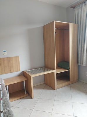Ein Zimmer mit Holzschrank, einer Bank und einem Bett.