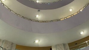 A multi-level atrium with a circular design, featuring a central light fixture and multiple balconies.