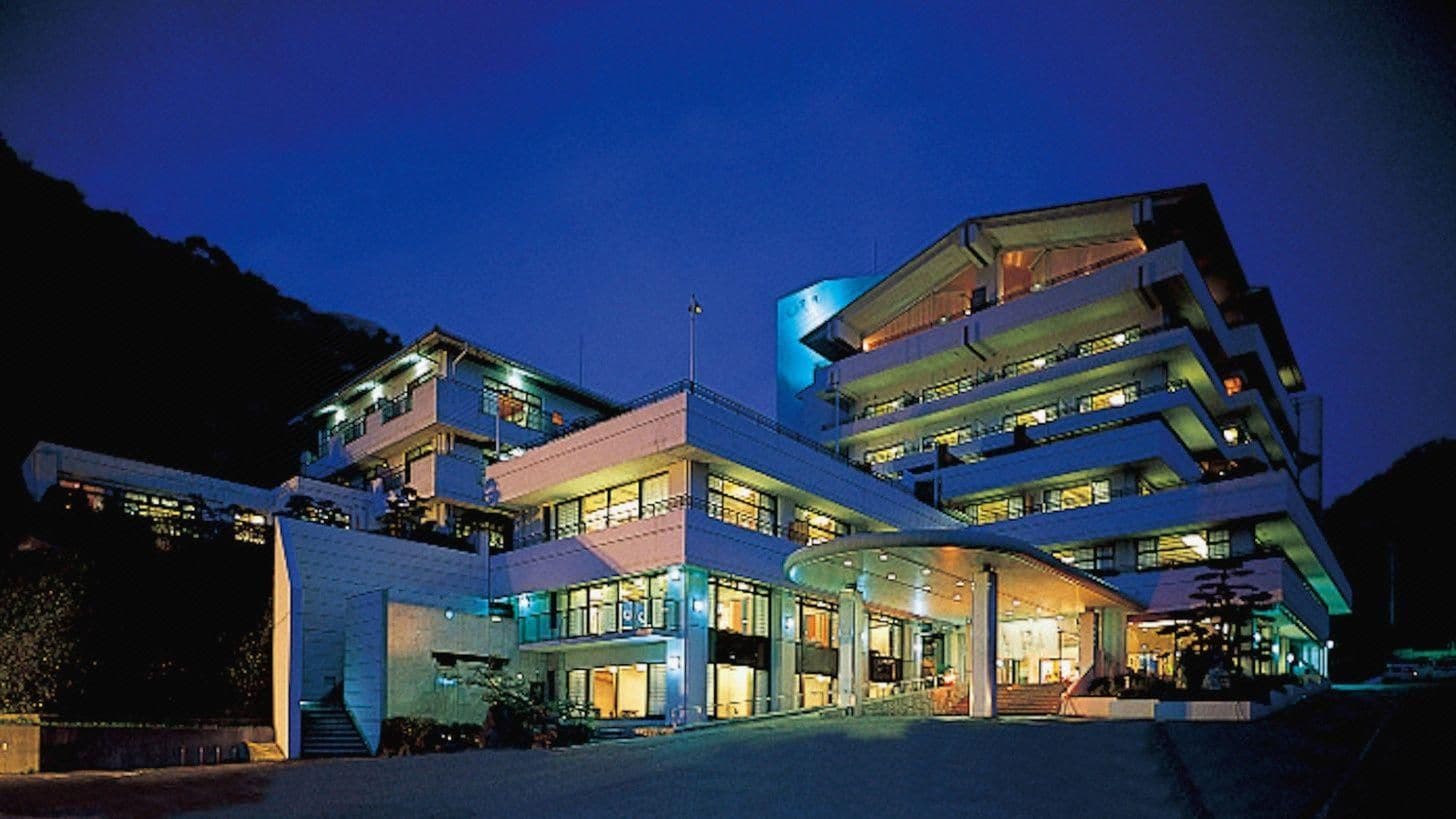 A multi-story hotel with a curved entrance and balconies.