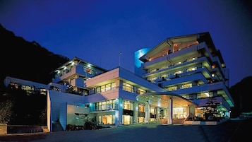 Un hotel de varios pisos con una entrada curva y balcones.