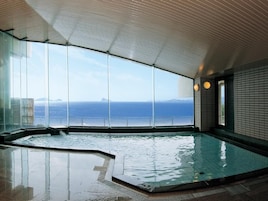 A large indoor swimming pool with a view of the ocean.