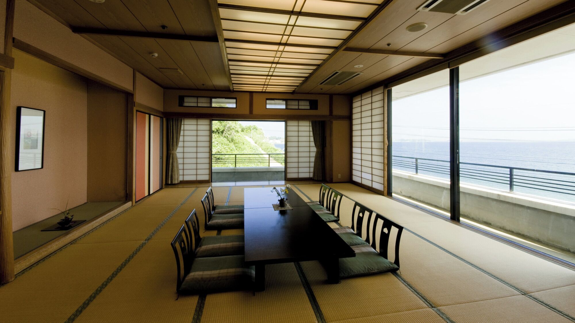 A traditional Japanese room with tatami flooring, a low table, and sliding doors.