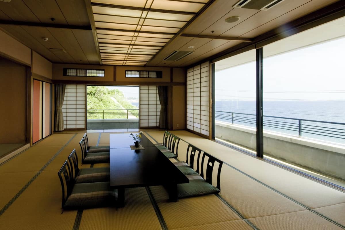 A traditional Japanese room with tatami flooring, a low table, and sliding doors.