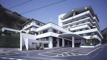 Um edifício moderno de vários andares com telhado plano e área de entrada coberta.