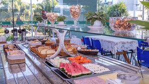 A buffet with various food items, including fruits, pastries, and a glass dessert. - Aojesp Hotel Colonia (Caraguatatuba)