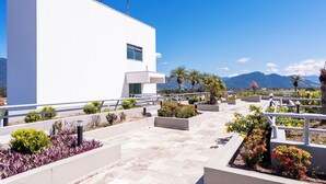 A modern building with a flat roof, a balcony, and a view of mountains. - Aojesp Hotel Colonia (Caraguatatuba)