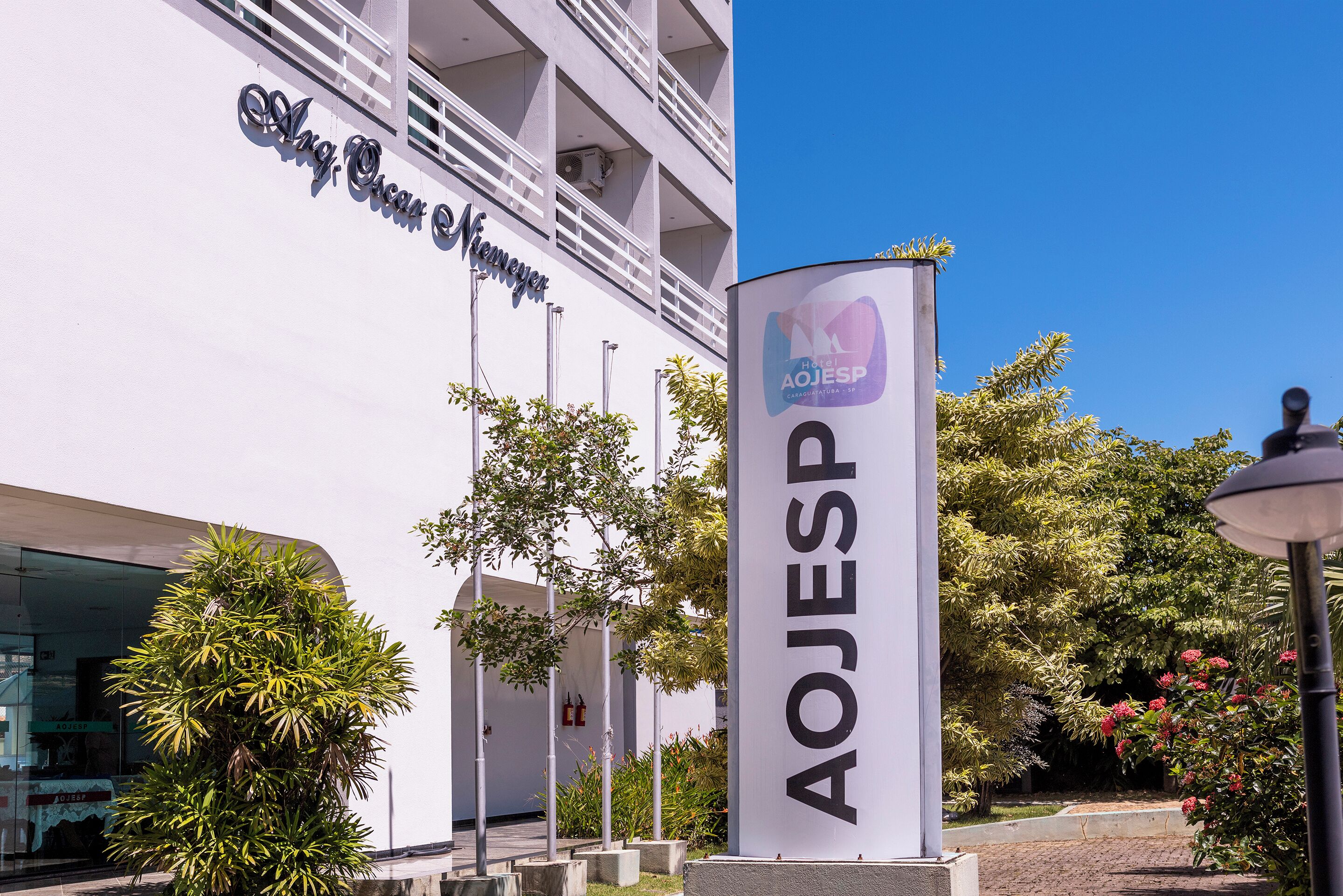A building with a sign reading 'AOJESP' and a balcony with railings.