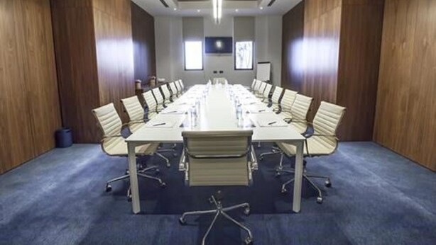 A conference room with a long table, chairs, and a projector screen. - Hotel Dar El Aaz (Algiers)