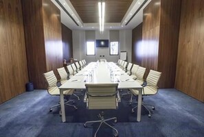 A conference room with a long table, chairs, and a projector screen. - Hotel Dar El Aaz (Algiers)