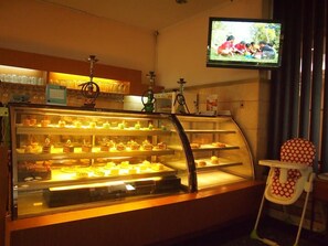 Une vitrine de pâtisserie remplie de diverses viennoiseries, avec un narguilé en arrière-plan.