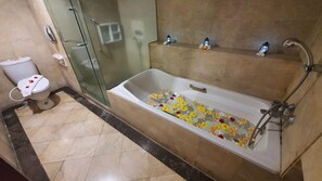 A bathroom with a bathtub, toilet, and glass shower enclosure.