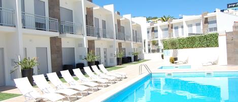 A poolside area with lounge chairs and a swimming pool.