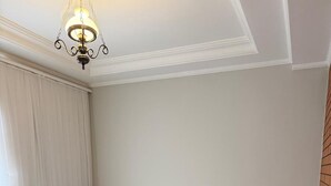A hotel room with a large bed, wooden headboard, bedside lamps, and a hanging light fixture. - Hotel Pantanal Vila Mariana (São Paulo)