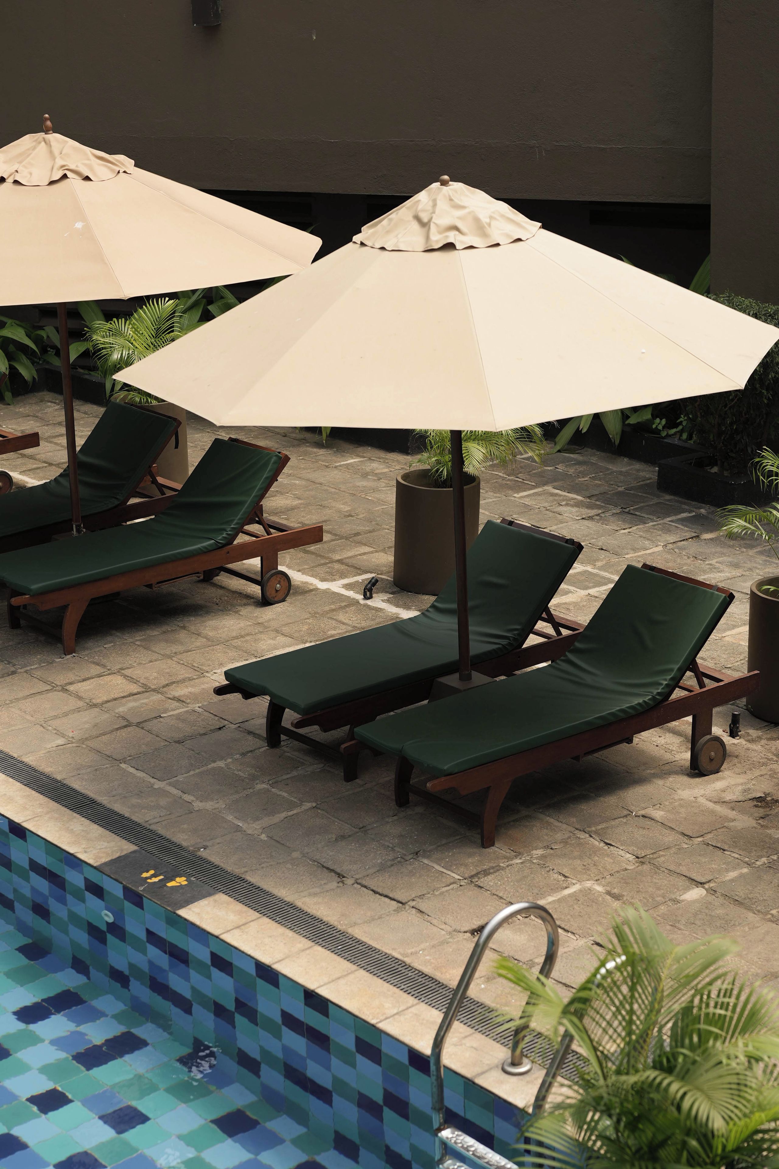 A poolside area with lounge chairs and umbrellas.