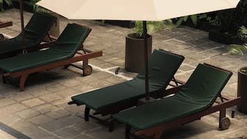 A poolside area with lounge chairs and umbrellas.