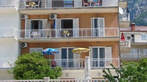 Un immeuble à plusieurs étages doté de balcons, de climatiseurs et de mobilier d’extérieur.