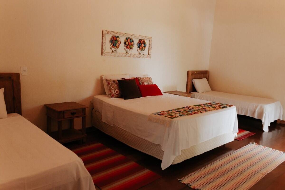 Una habitación con dos camas individuales, una mesita de noche pequeña y una obra de arte colgada en la pared.