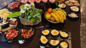 Ett buffébord med ett varierat utbud av mat, inklusive kött, frukt och bakverk.