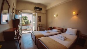 Habitación de hotel con dos camas, un escritorio, una silla, un televisor y un balcón con vistas.
