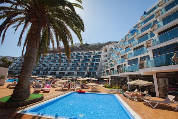 Alberca al aire libre y camastros