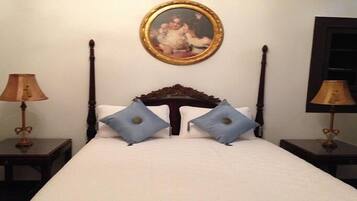 Una camera d'albergo con un letto grande, due comodini, due lampade e un quadro incorniciato al muro.