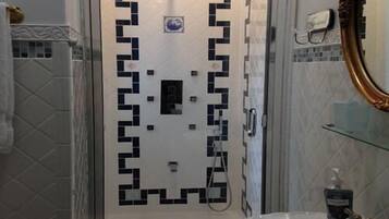 A bathroom with a white sink, a mirror, and a shower area.